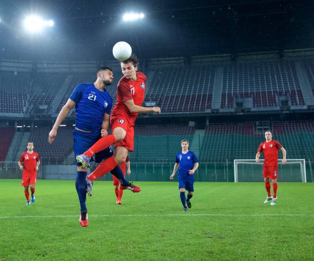 Football player jumping and heading the ball.